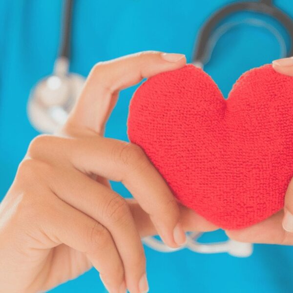 A nurse holding a red heart in San Francisco.