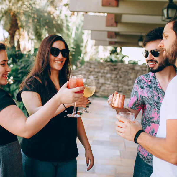 A small group of friends toasting drinks in a courtyard during their California tour.