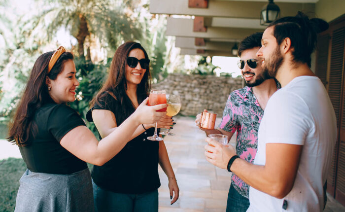 A small group of friends toasting drinks in a courtyard during their California tour.