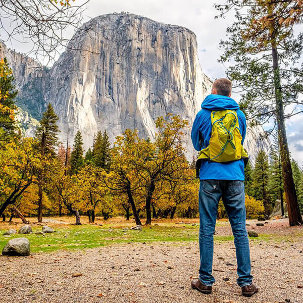 A man is standing in front of a mountain in Yosemite National Park on a small group tour from San Francisco, California.