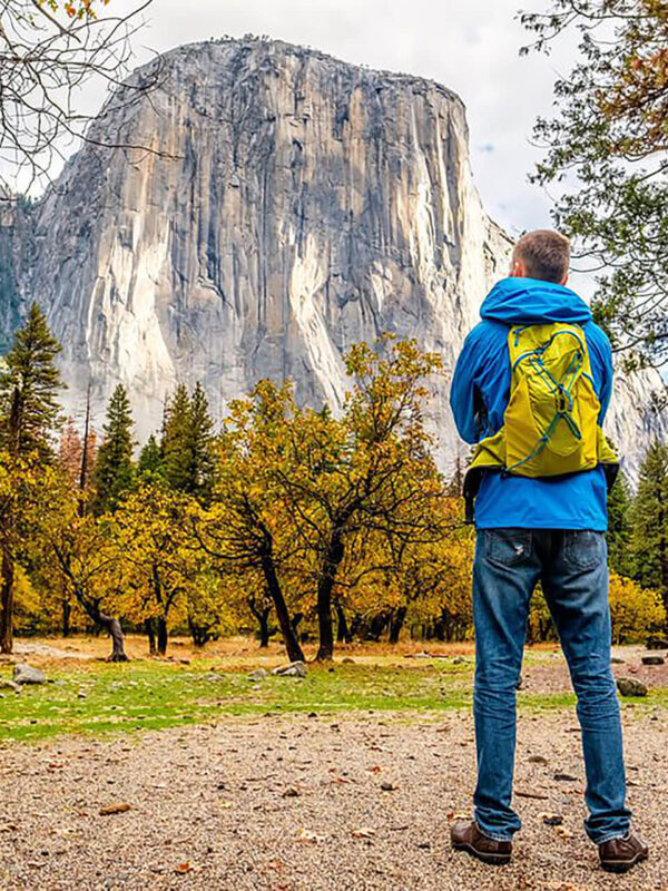 A man is standing in front of a mountain in Yosemite National Park on a small group tour from San Francisco, California.