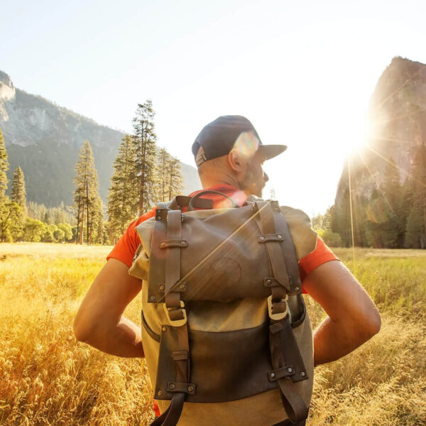 A man with a backpack exploring Yosemite National Park in California.