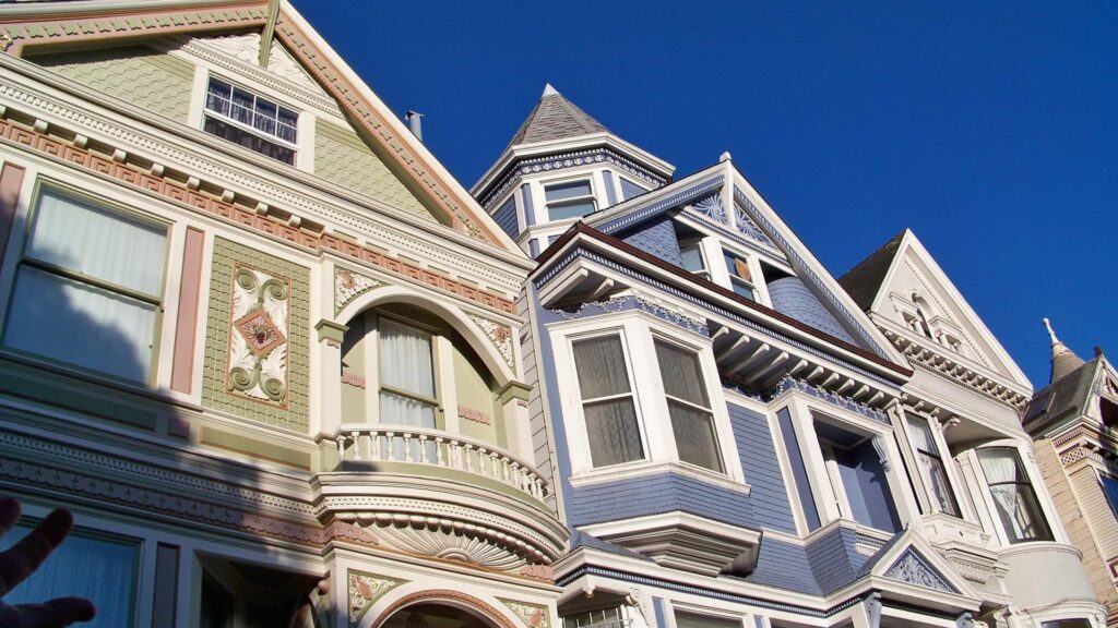 Victorian houses with intricate facades under a clear blue sky.