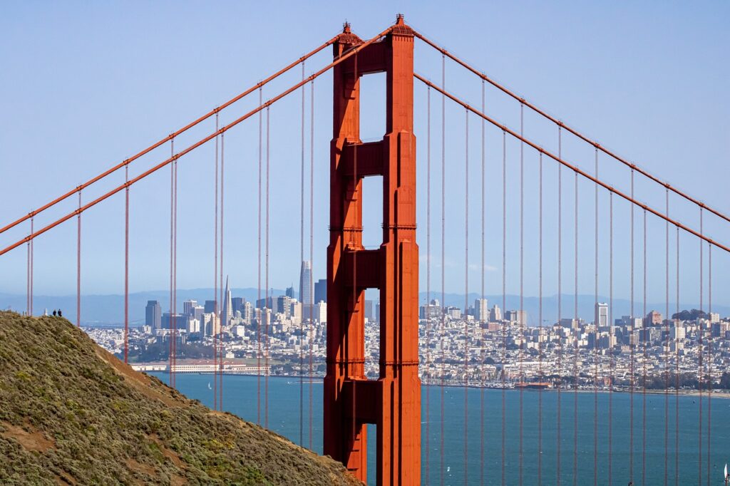 The Golden Gate Bridge, painted in reddish-orange, stands prominently with the San Francisco skyline visible in the background.